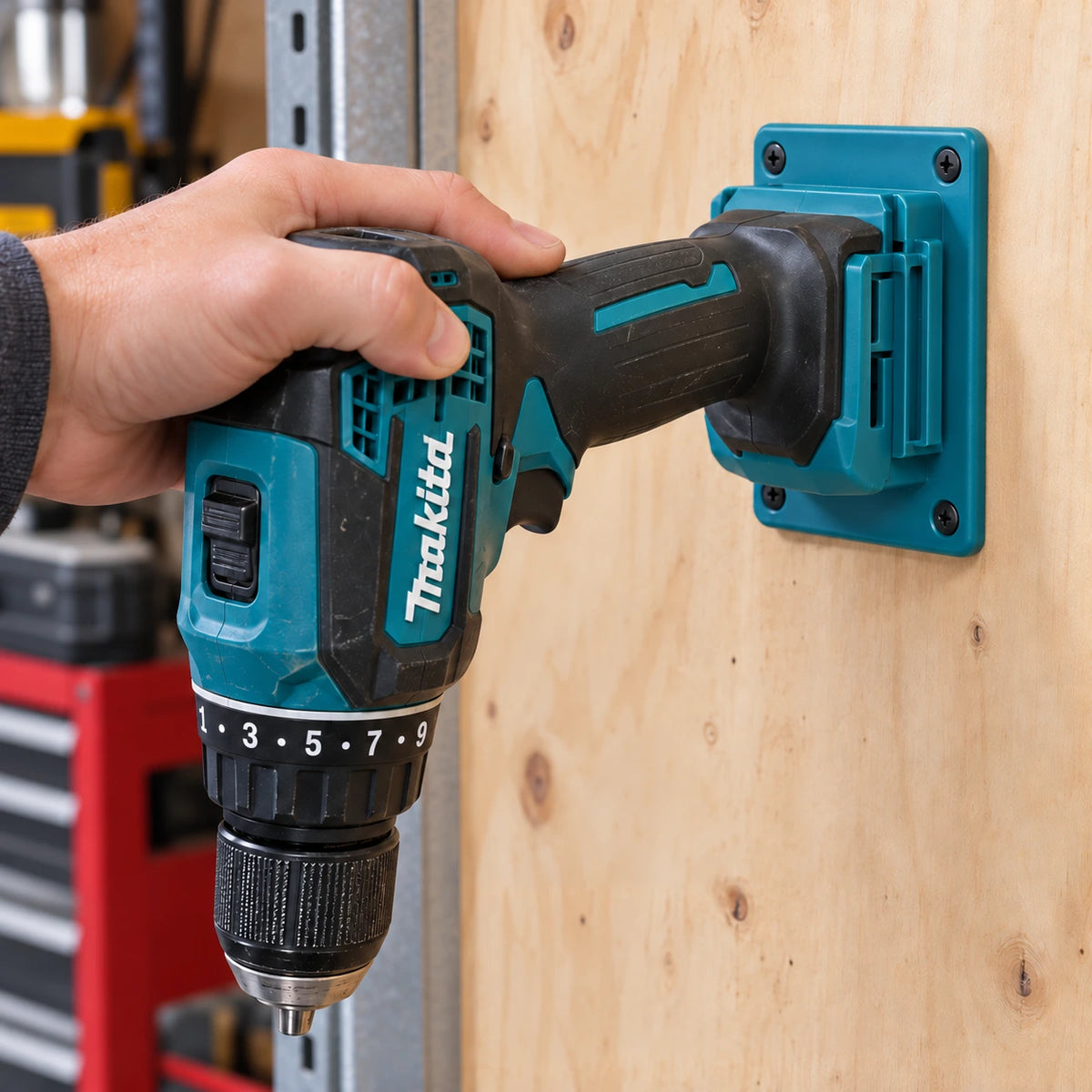 En hand skjuter in en Makita-borrskruvdragare i en turkos hållare via batterifästet